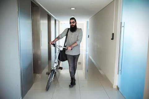 Man walking through corridor with bicycle Stock Photos