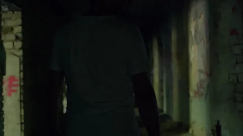 Man walking through dark abandoned corridor Video stock 304516944