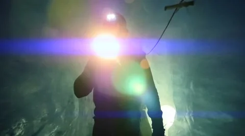 Man walking through dark ice cave using a flashlight. blue mystical scene Video stock 42950600