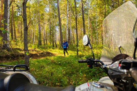 Man walking through a forest while exploring nature and Quadbike or ATV Stock Photos