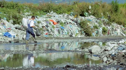 Man walking through Garbage dumping in the river in Batumi, Georgia. Видео 50637722