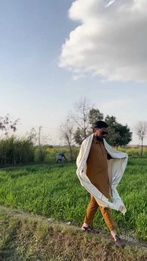 Man Walking Through Green Field Vídeo Stock 334729641