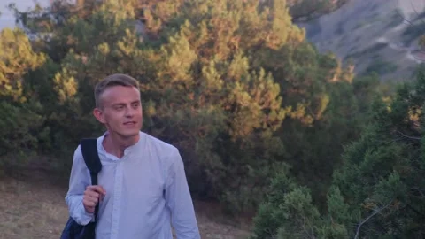 A man walking through a juniper grove against the backdrop of mountains Video stock 158306732