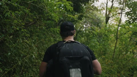 Man Walking Through Lush Tropical Forest with Backpack 4K Stock Footage 267048308