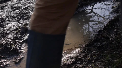 Man walking through muddy field, CU Stock Footage 35597628