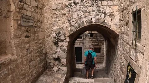 A man walking through the narrow streets of Dubrovnik old town, Croatia Stock Footage 255791106