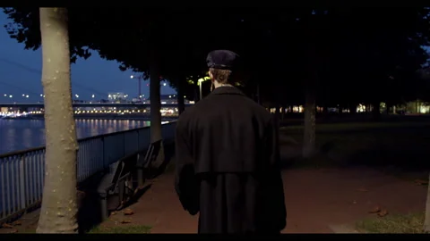 Man walking through the night next to a river Stock Footage 238862726
