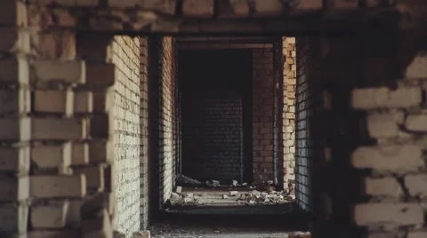 Man walking through an opening in a brick wall Video stock 48583724