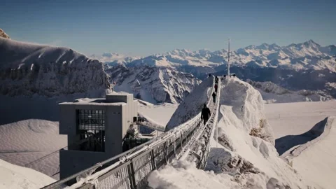 Man walking through the Peak Walk bridge on Sex Rouge in winter, Glacier 3000 Stock Footage 224744311