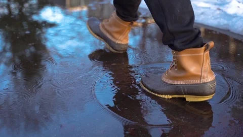Man walking through puddle with boots in slow motion Stock Footage 105205915
