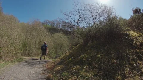 A man walking through a quarry in bright sunshine Stock Footage 153907893