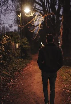 A man walking through the road at night Stock Photos