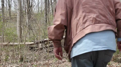 Man walking through some thick woods Stock Footage 22771945