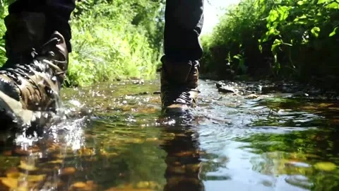 Man Walking Through Stream. Hiking through Water in Nature. Video stock 306515962