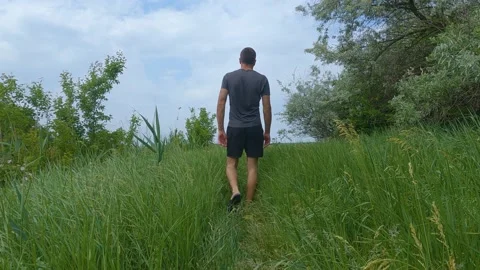 Man walking through tall grass SlowMo 库存影片 196787094