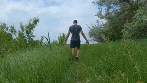 Man walking through tall grass SlowMo Video stock 196787200