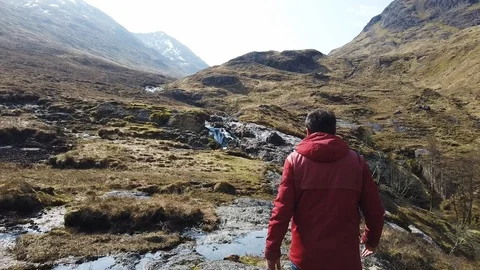 Man walking through waterfalls in Scotland Stock Footage