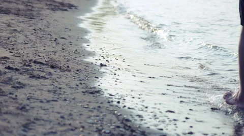 Man walking through waves at the beach Stock Footage 40763870