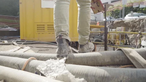 Man walking through working industrial site. Follow shot to a male worker feet Stock Footage 128885617
