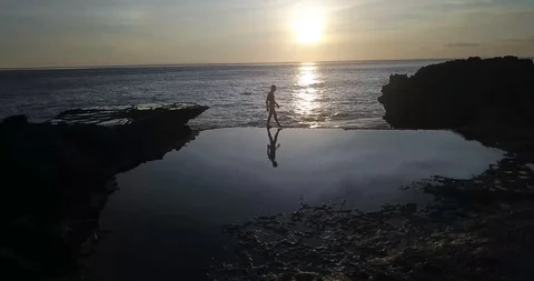 Man Walking on Tide Pool at Sunset Nusa Penida Stock Footage 106787990