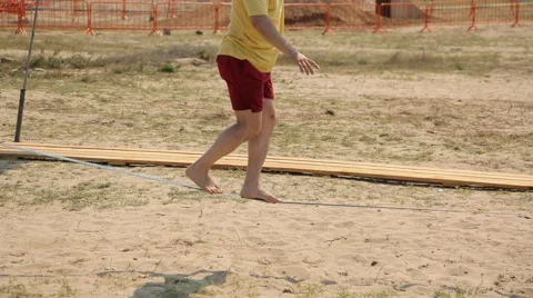 Man walking on a tightrope on the beach Video stock 59156974