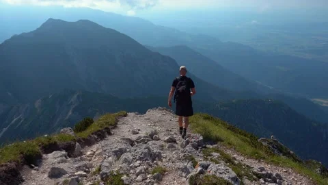 A man walking on top of a mountain with a backpack Stock Footage 210535327