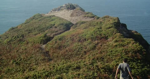 Man Walking Toward Cabo Peñas Viewpoint on Windy Asturias Clifftop Coast, Spain Stock Footage 341436569