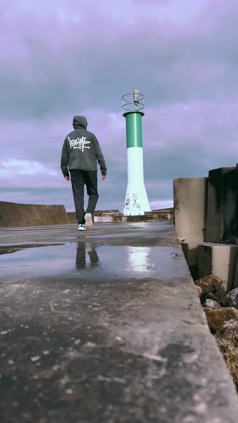 Man Walking Toward Lighthouse, Rainy Pier – Rabat Morocco Stock Footage 303966839