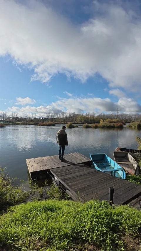 Man Walking Toward a Small River Dock Stock Footage 322170864