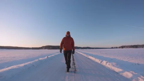 Man walking towards the camera on an icy road on the cold winter morning Stock Footage 148754709