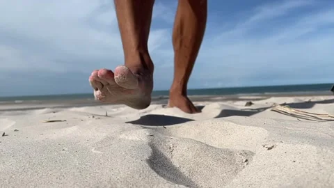 Man walking towards the camera sandy beach landscape blue sky sunny beach Video stock 252161310