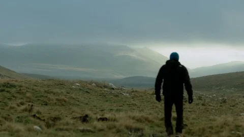 Man Walking Towards The Mountains Stockbeeldmateriaal 75207156