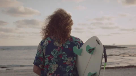 Man walking towards the ocean with his surfboard Stock Footage 275164987