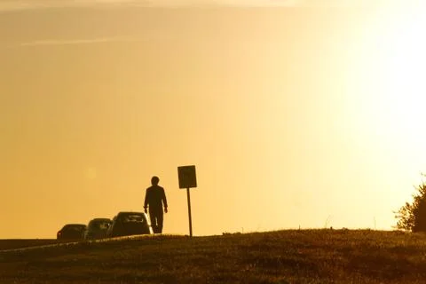 Man walking towards the sunset Stock Photos