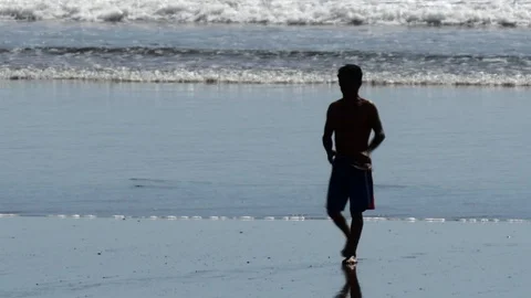 Man walking towards us on beach Stock Footage 126669483