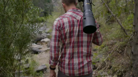 Man walking on a trail with lens on back Stock Footage 54709588
