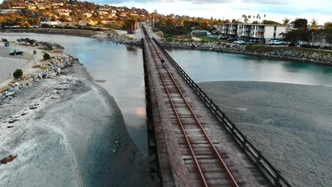 Man walking on train bridge over water 库存影片 86296584