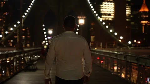 A man Walking Trough on the Brooklyn Bridge at Night 스톡 동영상 249916551