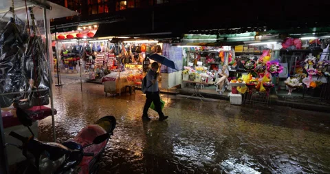 Man walking with umbrella at empty night market in rain Stock Footage 319637245