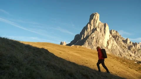 Man walking uphill with backpack and Dolomite Alps Video stock 201165101