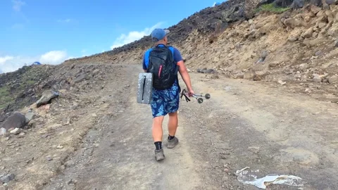 Man walking uphill in rear view on a rough access road on Mount Ararat Stock Footage 343804818