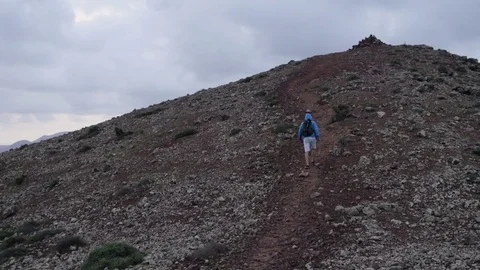 Man walking up the volcanic hill Stock Footage 71552566