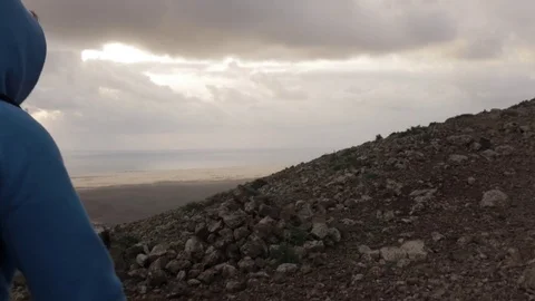 Man walking on the volcanic mountain during sunset Stock Footage 71553596