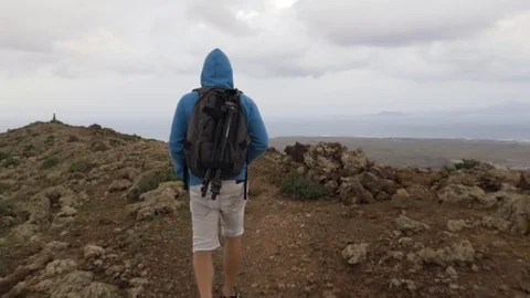 Man walking on the volcanic mountain Stock Footage 71553158