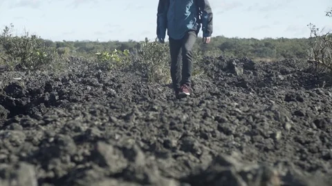 Man Walking on Volcanic Rocks Stock Footage 79054081