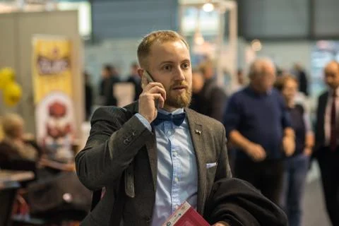 A man is walking while speaking on the phone at the convention trade center i Stock Photos
