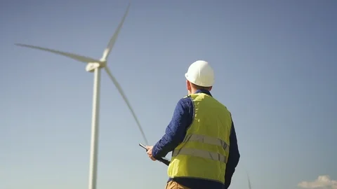 Man walking to wind mill and checking condition of mechanisms Stock Footage 113998896