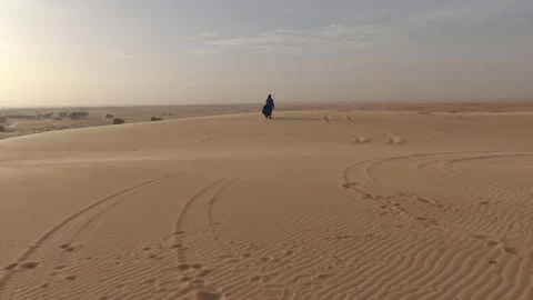 Man walking in the wind, on sand dune, Sahara, Chinguetti, Mauritania Video stock 149649215