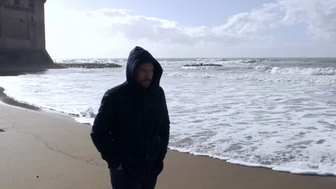 Man walking in winter in front of the wild ocean Stock Footage 115591314