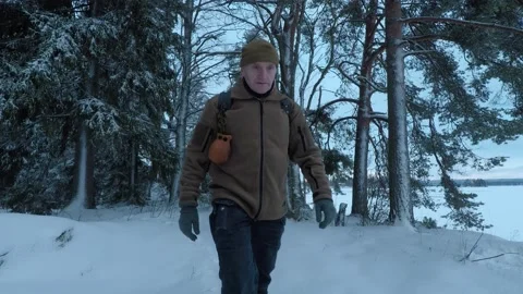 Man walking from woods towards camera during midday blue light Stock Footage 146728741
